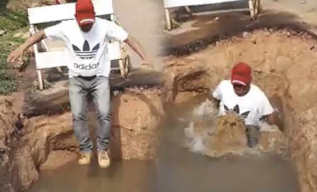 Em protesto, ativista pula em buraco que virou "piscina" em rua de Feijó