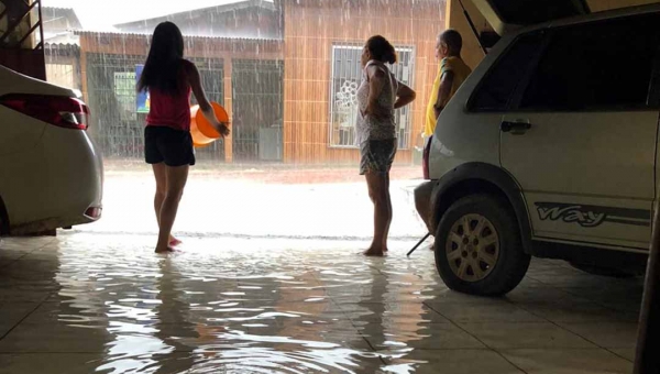 Moradora chora após ter parte da casa inundada durante a chuva em Rio Branco neste sábado; veja imagens