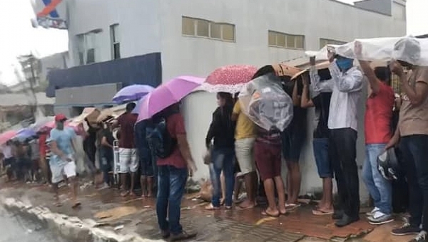 Sob chuva, fila gigante se forma do lado de fora de agência em Cruzeiro do Sul