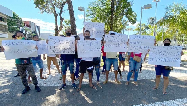 Com cartazes com as frases "queremos trabalhar" e "fora Bocalom", camelôs protestam no centro de Rio Branco