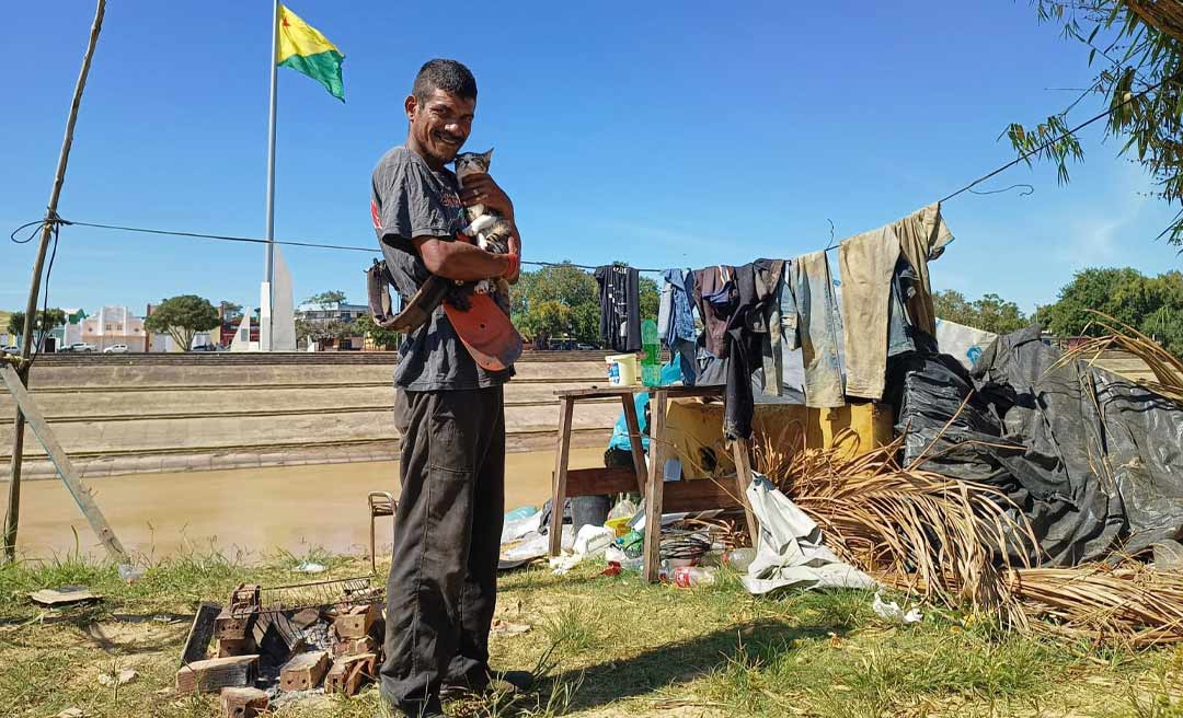 Pescador que teve barco furado mora em barraco de lona e palha na beira do rio Acre no Bairro da Base