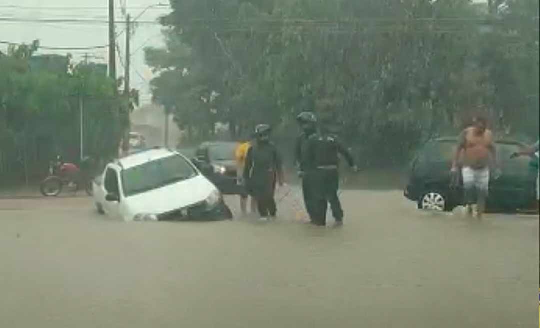 Carro cai em buraco em rua alagada por igarapé durante a chuva desta sexta-feira