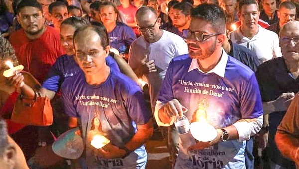 Ao lado de Cameli e rogando por “esperança”, Zequinha caminha com vela nas mãos na procissão de Nossa Senhora da Glória